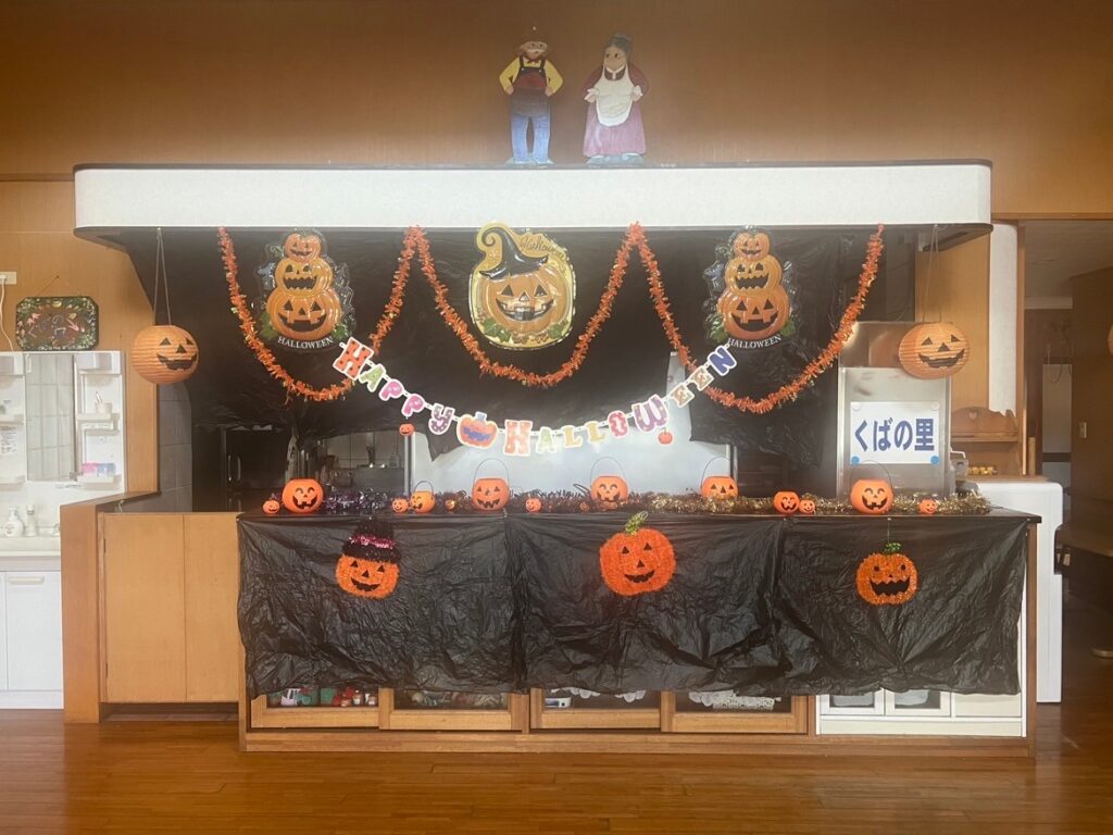 ハロウィン装飾が施された介護施設のロビー・受付エリア。カボチャランタンと飾りで季節感を表現。